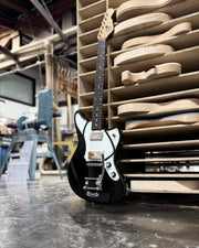Full view of black Riverton demo guitar with natural headstock and Bigsby